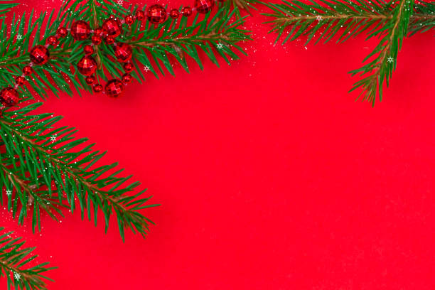 istock Christmas tree branches with red beads, snow, snowflakes with copy space on red background, top view. Greeting card for Christmas and new year. Beautiful Christmas background. 1281516969