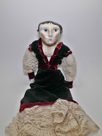 Closeup of an old artistic handmade vintage porcelain doll in black,blue dress