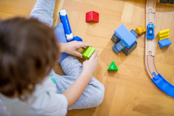 istock Little boy playing with a railroad train toy. 1281521575