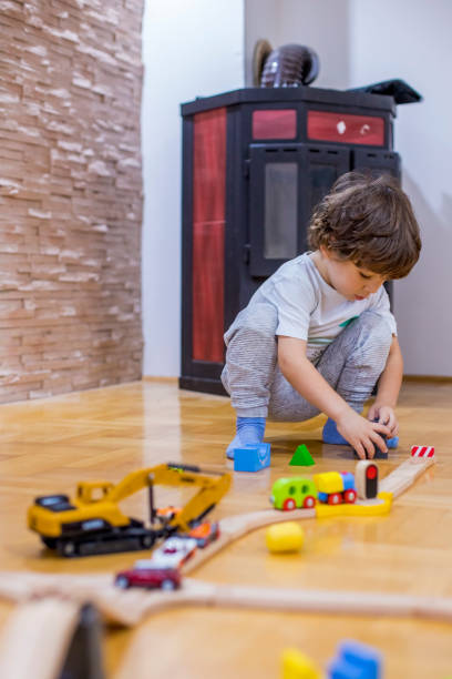 istock Beautiful little boy playing with a railroad train toy and plastic vehicle. 1281521725