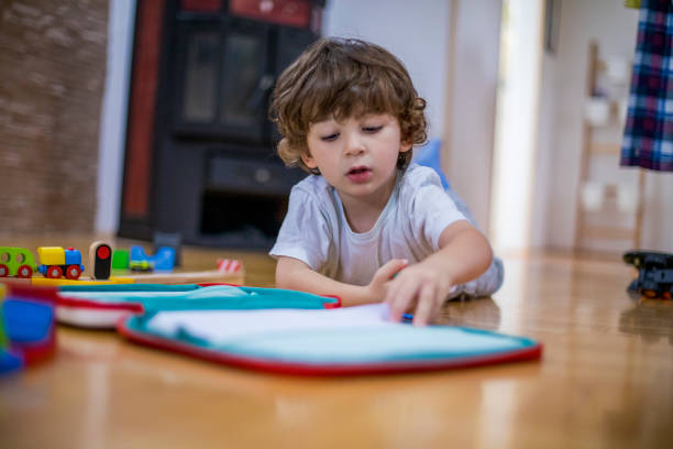 istock Beautiful toddler boy drawing using paper and crayons. 1281521798