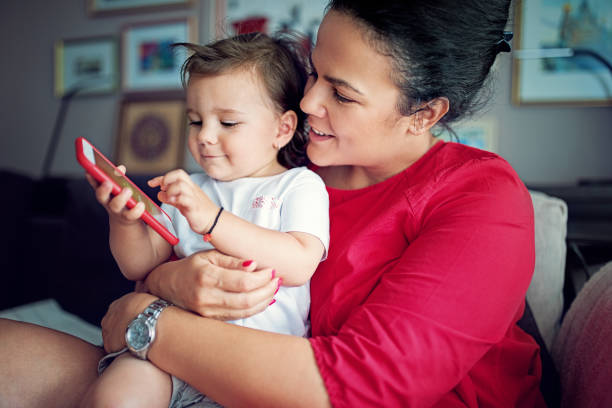 istock Mother and daughter are playing using mobile phone in home 1281523033