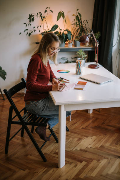 istock Hardworking young woman drawing sketches in her notebook 1281525376