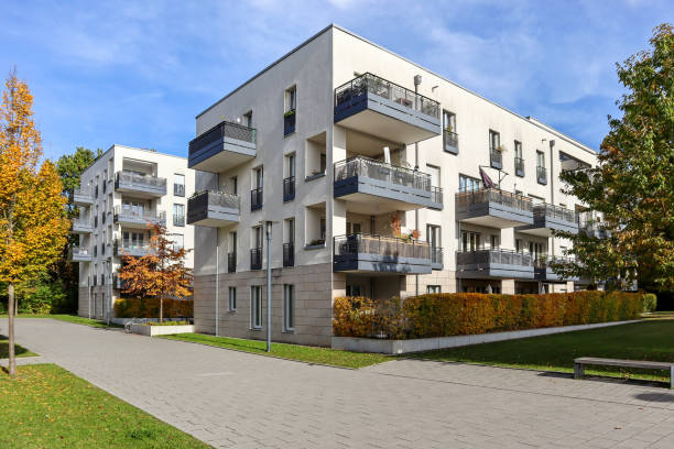 Cityscape with modern residential area, new apartment buildings and green courtyard with pedestrian walkway and trees in autumn Cityscape with modern residential area, new apartment buildings and green courtyard with pedestrian walkway and trees in autumn green building blocks stock pictures, royalty-free photos & images