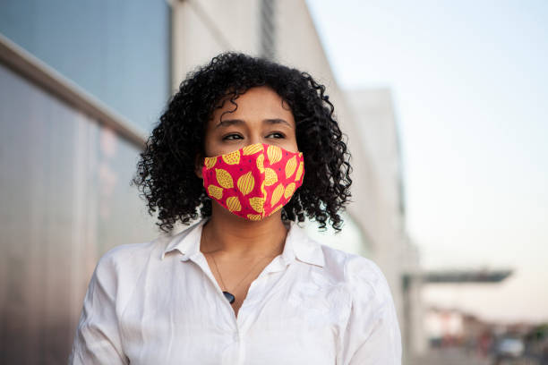 istock Afro black woman smiling with protective face mask 1281527024