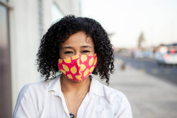 istock Afro black woman smiling with protective face mask 1281527025