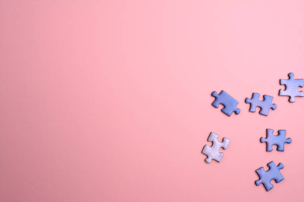istock some blue puzzle pieces on a smooth pink background 1281527197
