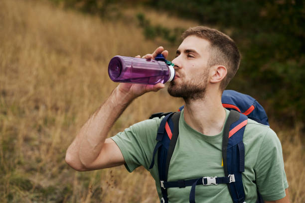 istock Young hiker taking a break while hiking and drinking water 1281527249