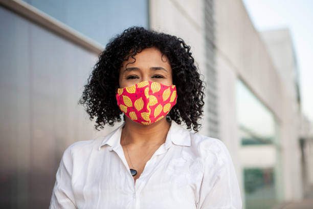 istock Afro black woman smiling with protective face mask 1281527260