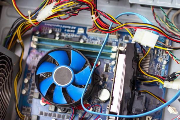 istock Old blue cooler fan with motherboard and colorful cables inside a computer 1281527269