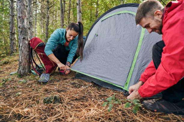 istock Young couple installing a tent in a mountain forest 1281528278
