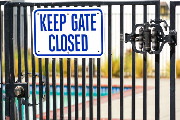 Keep Gate Closed warning sign on the locked entrance door to outdoor pool to remind people to keep the swimming pool gate closed Keep Gate Closed warning sign on the locked entrance door to outdoor pool to remind people to keep the swimming pool gate closed. pool gate stock pictures, royalty-free photos & images