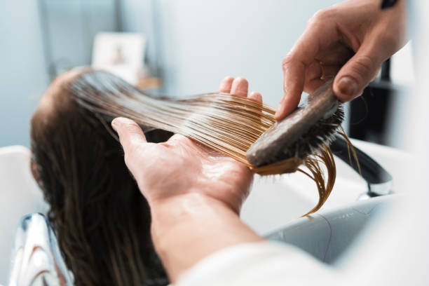 парикмахер чистит волосы стиральной женщины в парикмахерской на раковине - massage brush стоковые фото и изображения