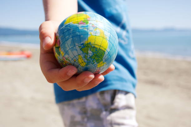 istock Personal Perspective, Child Plays with Globe Ball by Sea 1281532982