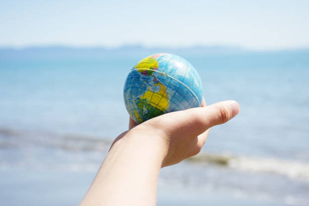 istock Personal Perspective, Child Plays with Globe Ball by Sea 1281533016