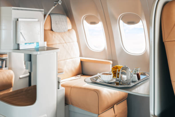 First Class Airplane Seat With Tray Of Food Dessert and coffee served on board of first class airplane on the table. seat stock pictures, royalty-free photos & images