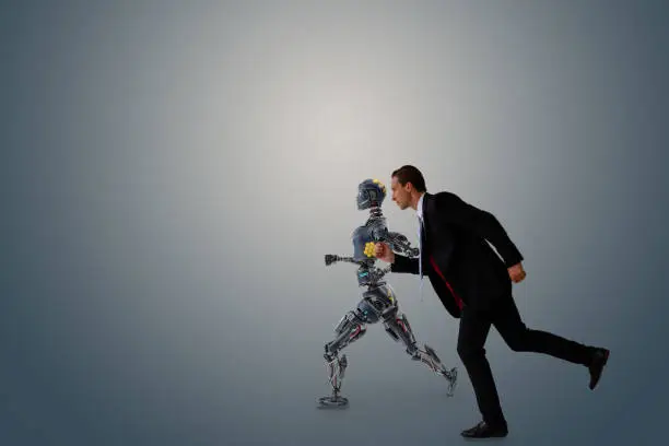 Photo of business man try to make a compete, race, battle, fight with robot or artificial intelligence for fight for work, chance, job, opportunity etc