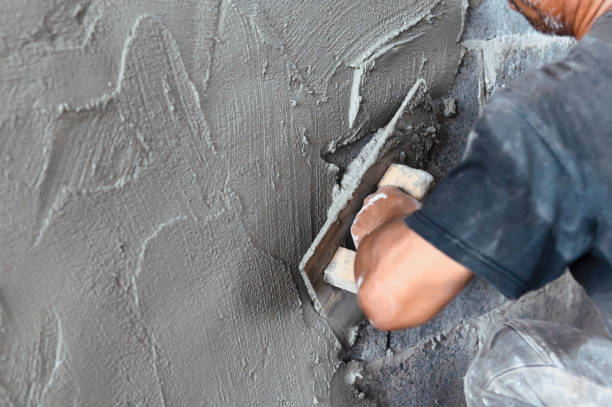 istock closeup hand of worker plastering cement at wall in construction site 1281539121