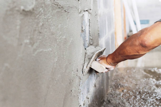 istock closeup hand of worker plastering cement at wall in construction site 1281539126