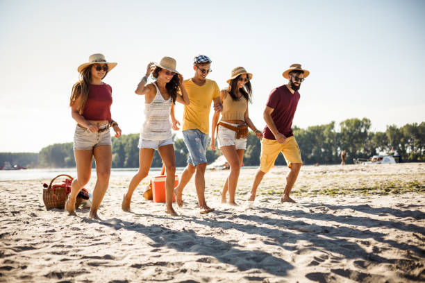 istock Friends enjoying a warm day and running on the beach 1281542837