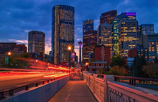 A view of the skyline of downtown Calgary illuminated under a sunrise sky.