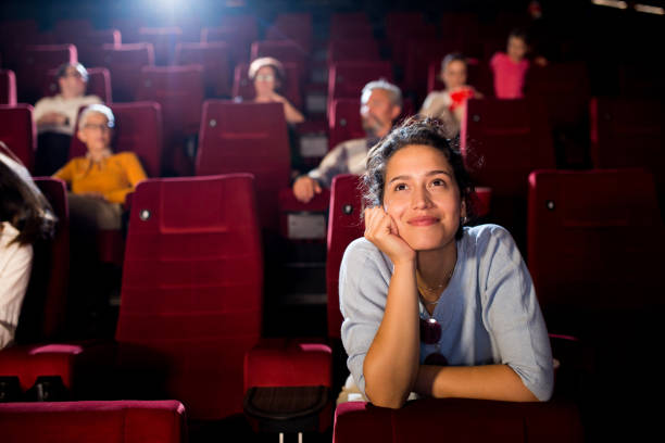 porträt einer jungen frau, die einen romantischen film im kino genießt - cinema theater stock-fotos und bilder