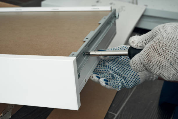istock Furniture assembly process. Worker in overalls and white footwear. Using a screwdriver. Do it yourself. 1281543720