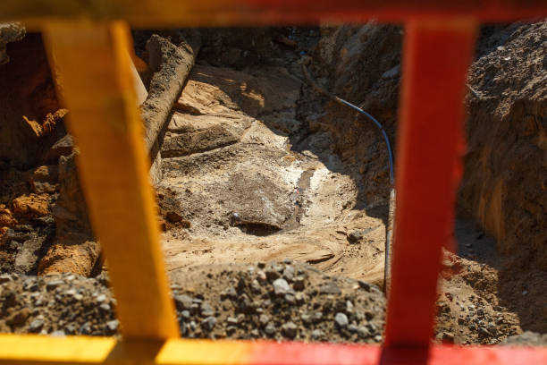 istock pit with a sewer pipe, view through a yellow fence 1281552740