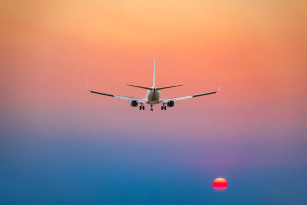 istock Commercial airplane flying above clouds in colorful sunset. 1281553708