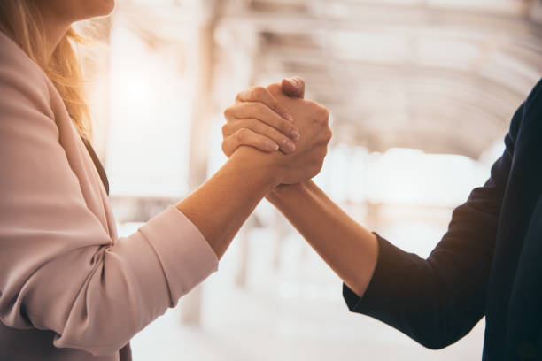 business partnership meeting trust handshaking concept. businesswomen doing arm wrestling. successful business people contract promise for good confidence dealing with skyscraper building background - team human hand cheerful close up imagens e fotografias de stock