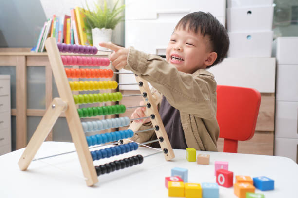 istock Cute little asian using the abacus with beads and wooden brick w 1281554643