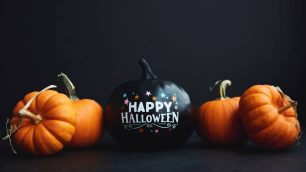 istock Halloween Background with Black and Orange Pumpkins and Happy Halloween Message 1281554800