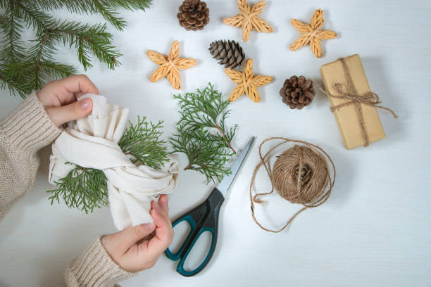 istock Gift in ecological packaging, fir branches, stars from a vine on a white background. Christmas gift wrapping in traditional Japanese furoshiki style. Flat lay, zero waste concept. 1281563070