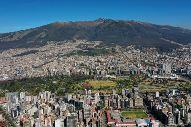 Aerial view of a city, a big park and a mountain in the background Pichincha vocano with a clear sky on the background, north side of Quito city and buildings surrounding La Carolina park quito photos stock pictures, royalty-free photos & images