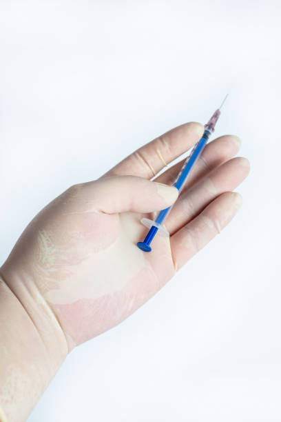 istock The hand holding the syringe.Isolated on a white background. 1281564070