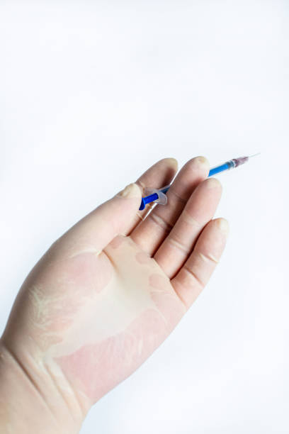istock The hand holding the syringe.Isolated on a white background. 1281564078
