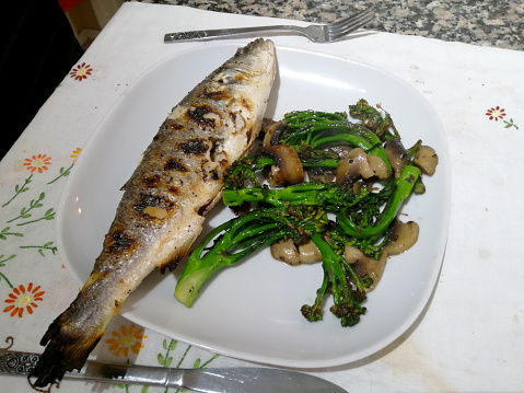Grilled whole sea bass with stem broccoli and mushrooms