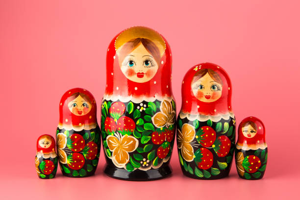 conjunto de juguetes de madera matryoshka sobre un fondo rosa - mamushka fotografías e imágenes de stock