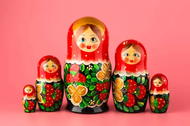 Set of wooden toys matryoshka on a pink background