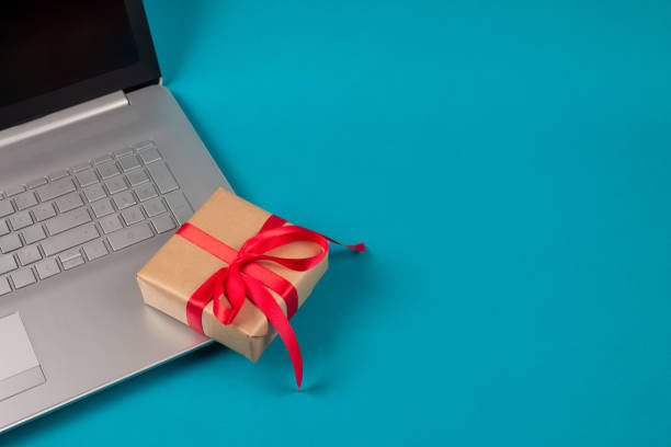 istock Front view on laptop computer and present box with red bow on green background with copyspace for your text. Seasonal sale, black friday and cyber monday. Online shopping and safe shopping concept 1281578425