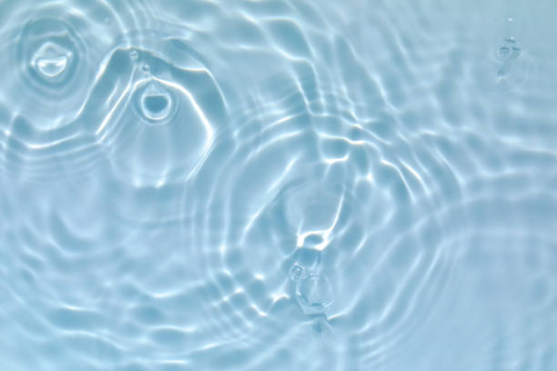 transparente blau gefärbt klare ruhige wasseroberfläche textur - water stock-fotos und bilder
