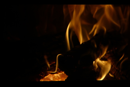 Fire and flames with a burning dark yellow-blured background.