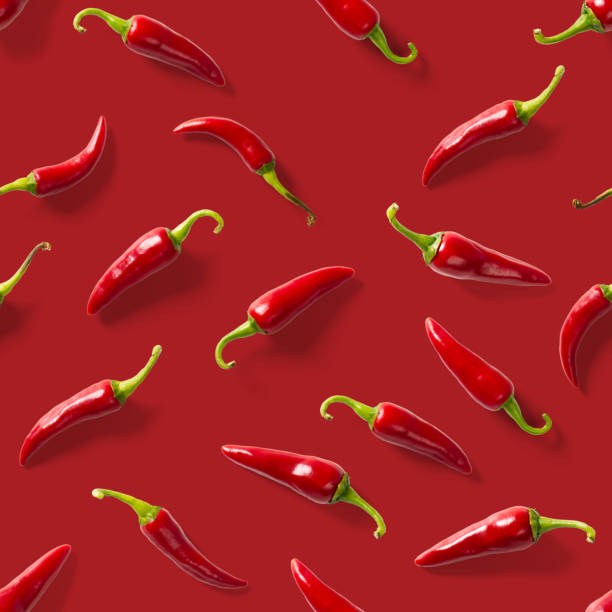 istock Seamless pattern made of red chili or chilli on red background. Minimal food pattern. Red hot chilli seamless peppers pattern. Food background. 1281584098