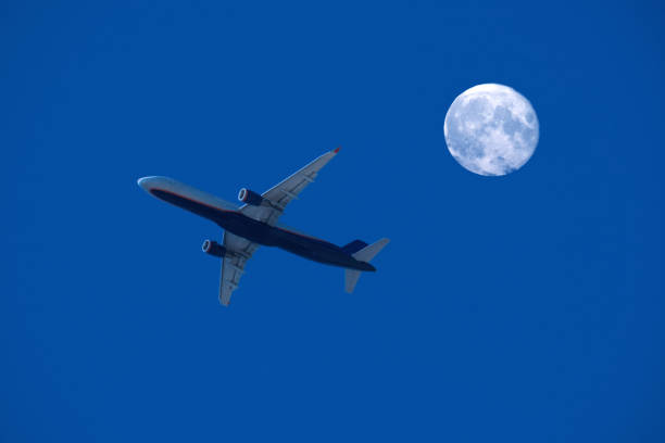 istock airplane flight against the full moon and blue sky 1281585474