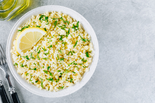 Lemon Herb Couscous in bowl on gray stone background
