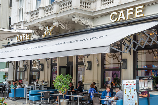 People enjoying coffee and pastries at the outside terrace of the famous Cafe Mozart in Vienna
