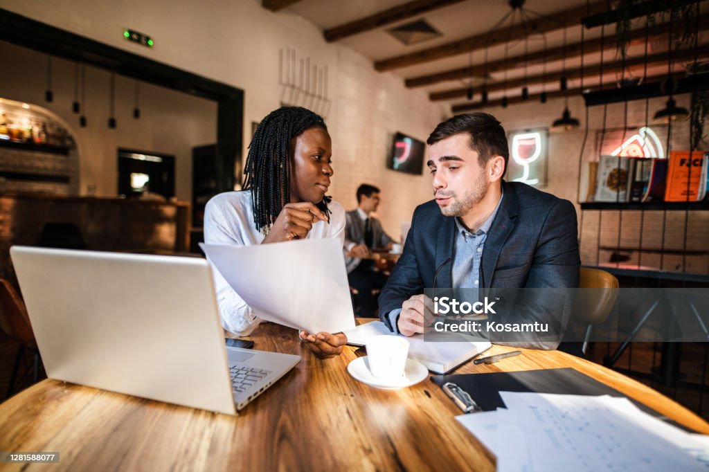 Female CEO Black ethnicity reprehend coworker for bad work results Modern hardworking coworkers finding solutions for business problem in a coffee shop during their coffee breal Investment Stock Photo