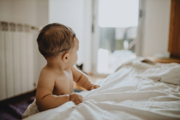 istock Cute Baby On Bed At Home 1281588546