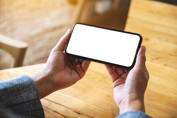 istock a woman holding mobile phone with blank white desktop screen 1281589530