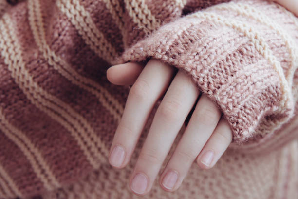 istock Woman in a beige soft warm sweater folded her hands 1281593136